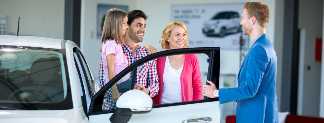 Cheerful family in car showroom